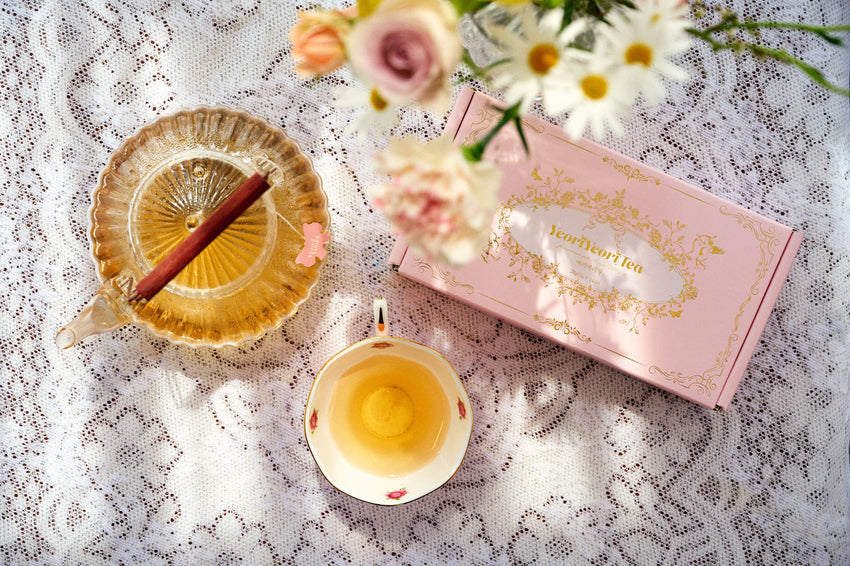 Filiżanka zaparzonej herbaty YeoriYeori obok opakowania – naturalny brzoskwiniowy aromat.