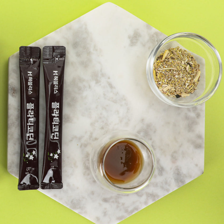 Oryginalne opakowanie produktu oraz mała szklanka wypełniona gęstym, ciemnym ekstraktem z korzenia dzwonka, gotowym do spożycia.